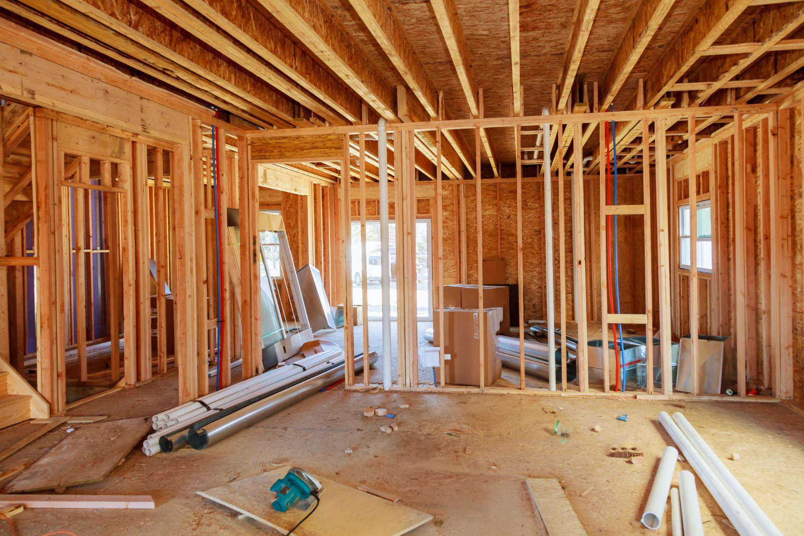 Interior of a home renovation project showing exposed wall framing, plumbing, and HVAC installations.