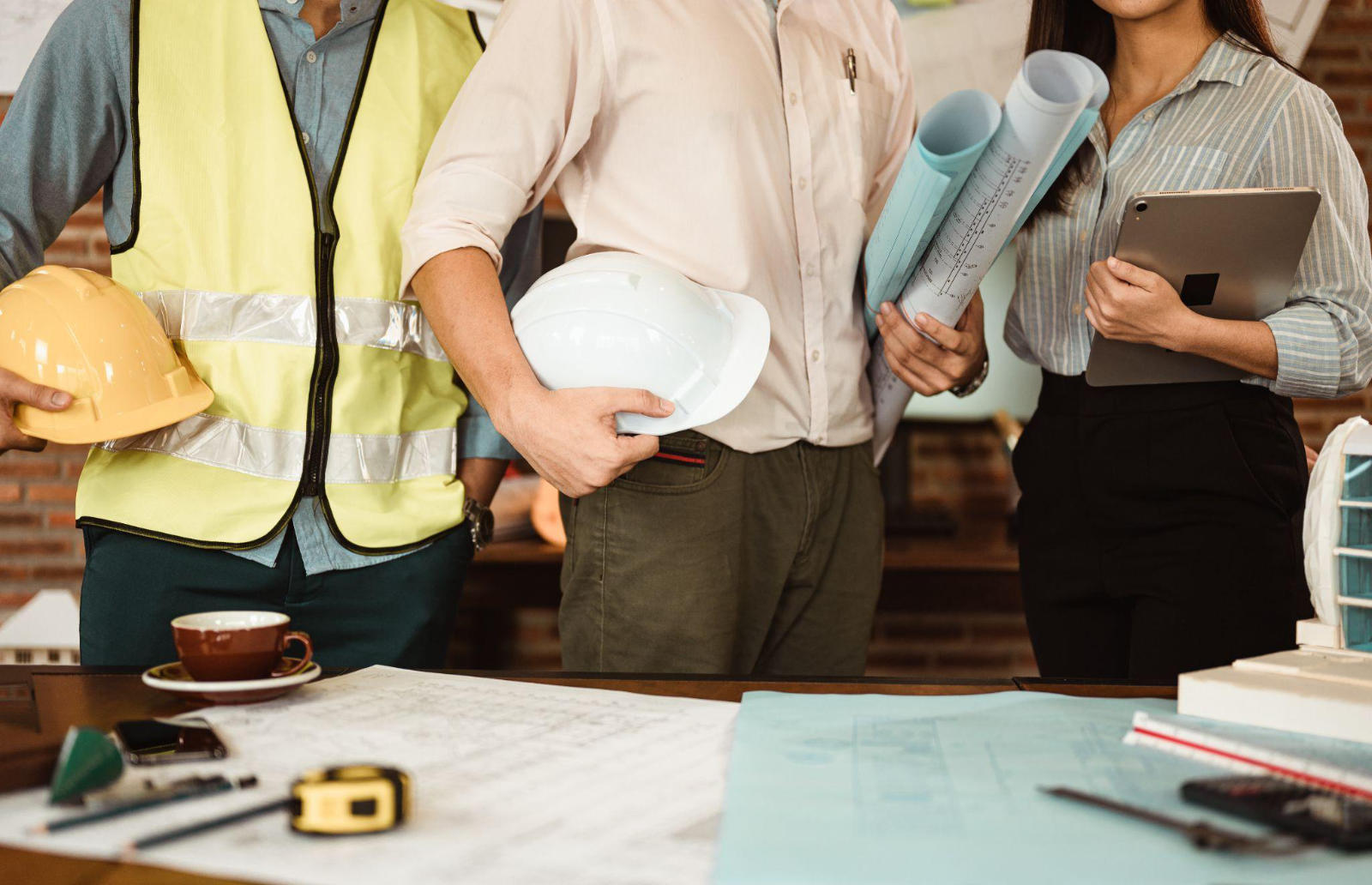 A professional renovation team holding blueprints and a tablet, showcasing an organized and expert approach to home remodeling projects.