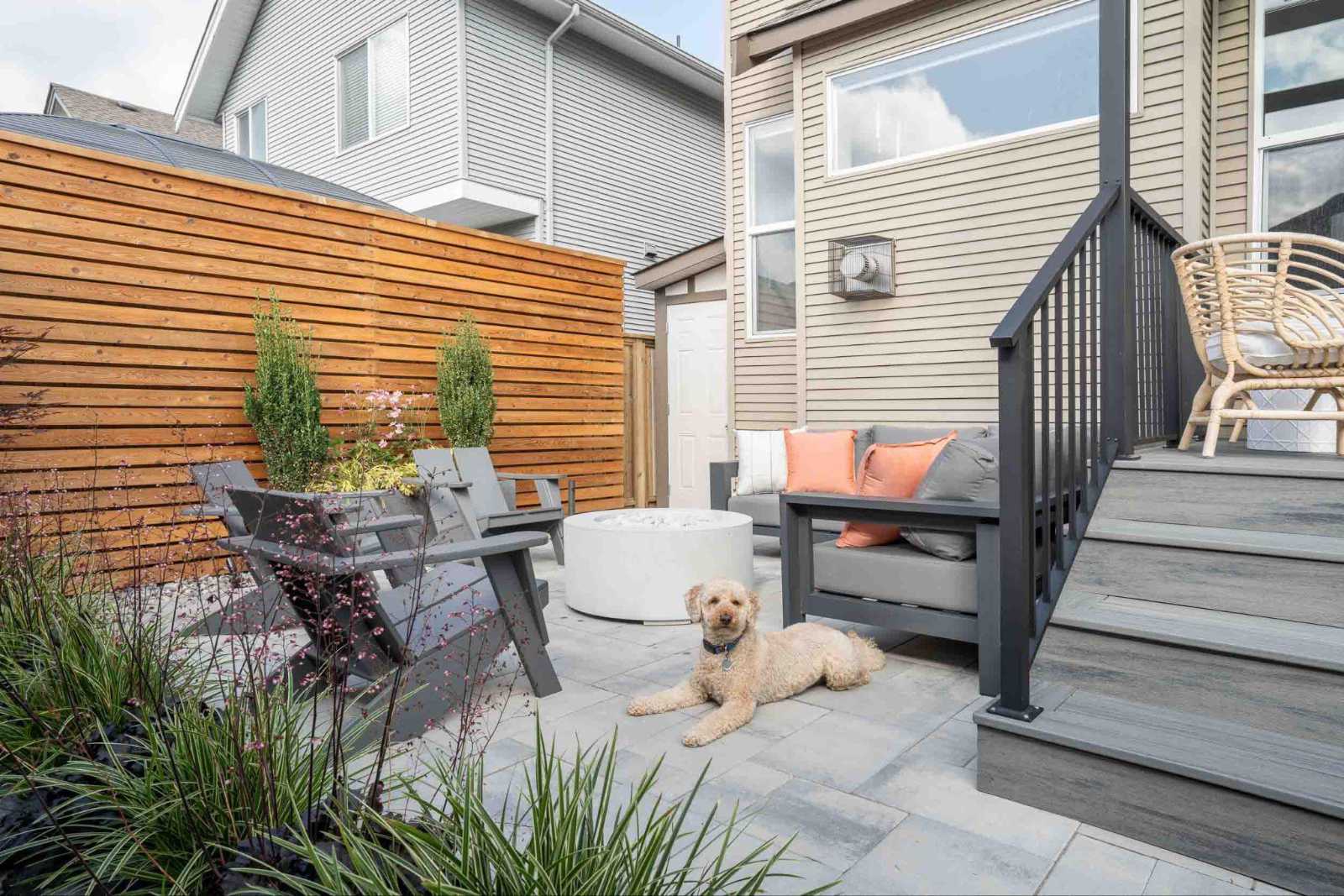 pre-construction-planning-outdoor-patio-renovation Modern outdoor patio featuring a fire pit, composite deck, wood privacy fence, and lounge seating planned during home pre-construction.