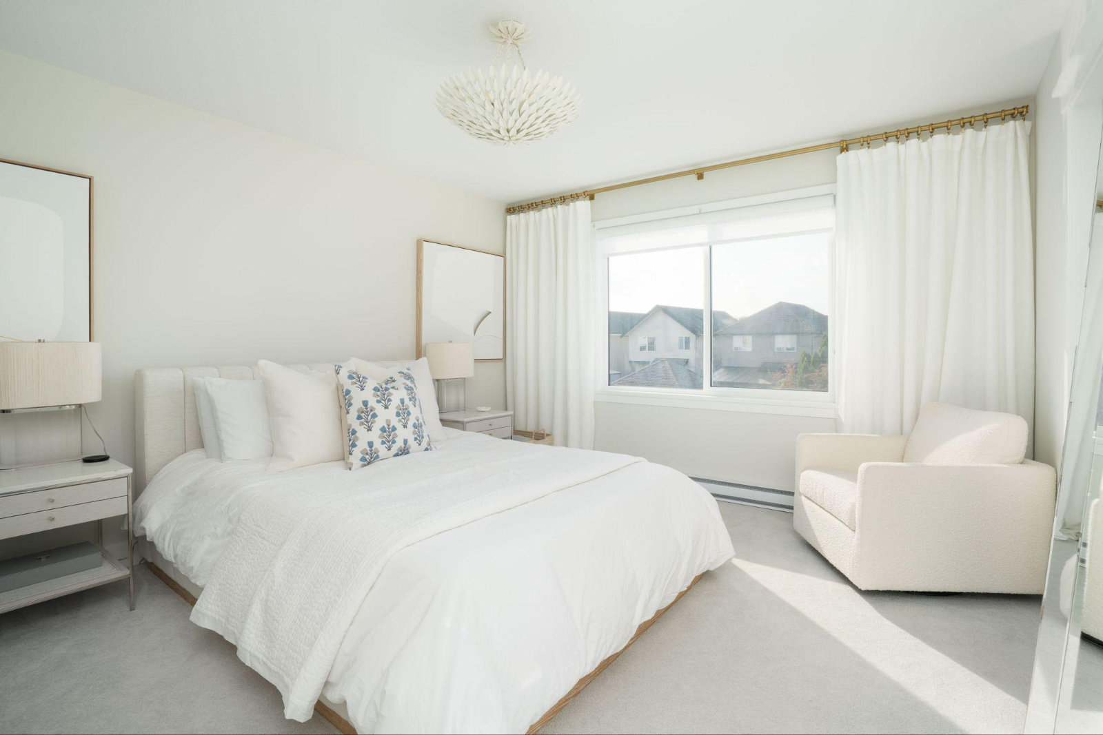 ight primary bedroom with custom floor-to-ceiling drapery, wide windows, upholstered headboard, and neutral decorative furnishings.