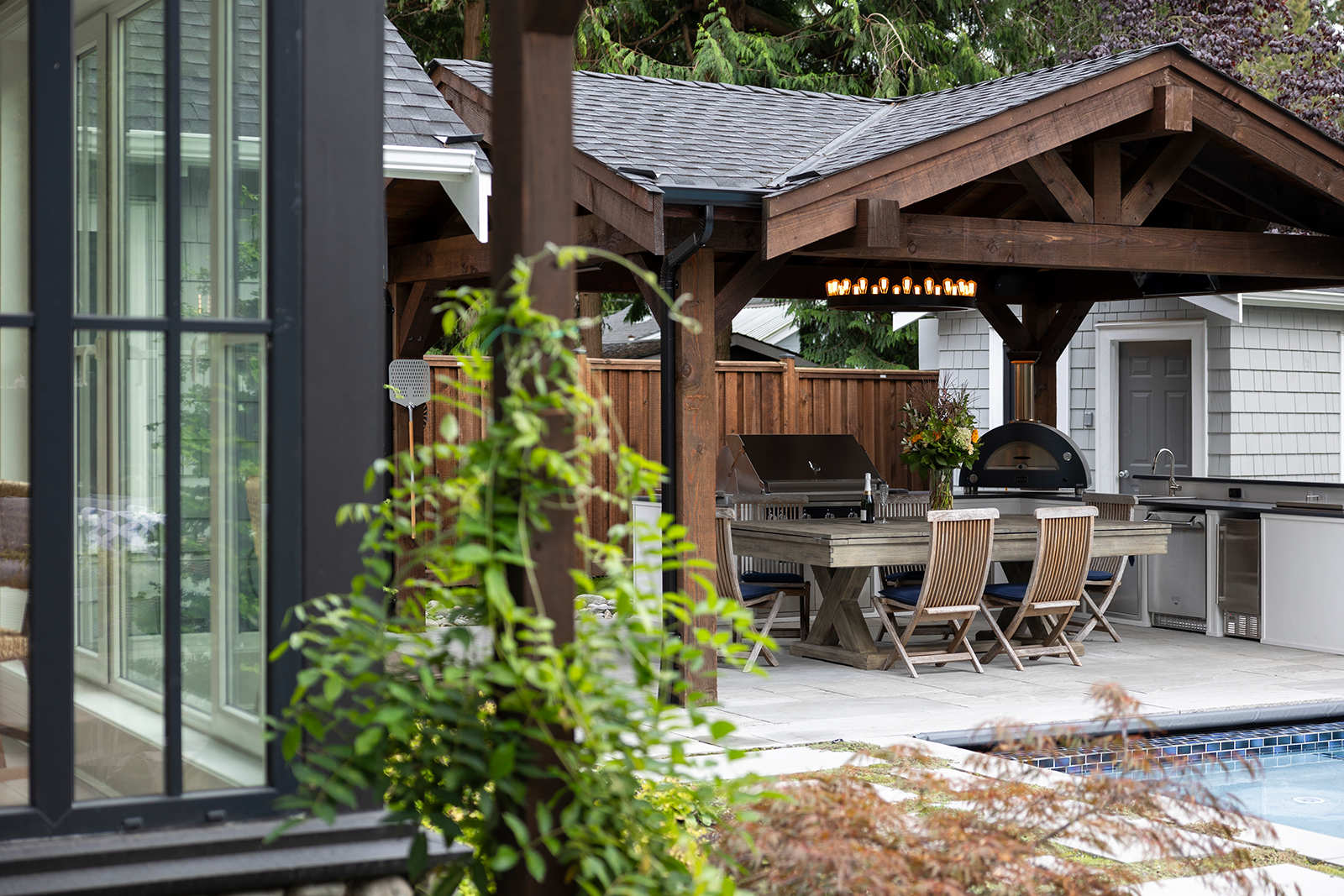 Outdoor dining patio and timber pavilion showing potential outdoor living additions when buying a home to renovate.